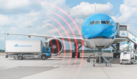 KLM-Flugzeug an einem Flughafentor mit einem Catering-LKW daneben, der mit roten Radarwellen die Annäherungserkennung anzeigt.